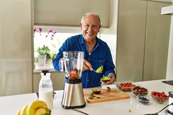 Hombre Mayor Sonriendo Confiado Cortando Aguacate Cocina —  Fotos de Stock