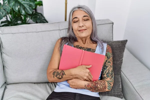 Middle Age Grey Haired Woman Smiling Confident Hugging Book Home — Fotografia de Stock