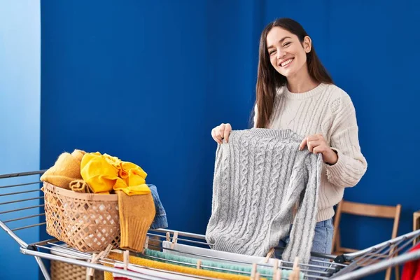 Mujer Joven Sonriendo Confiado Colgando Ropa Tendedero Sala Lavandería —  Fotos de Stock