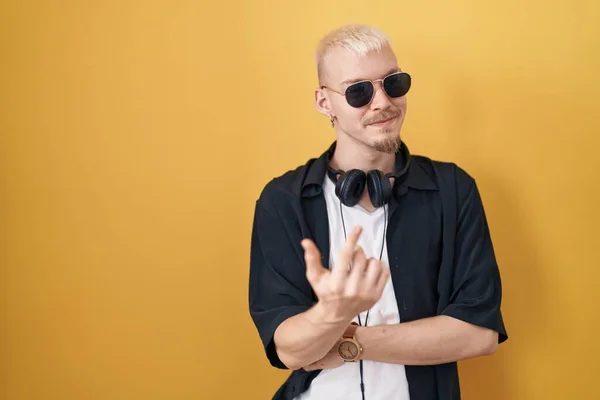 Jonge Blanke Man Met Een Zonnebril Gele Achtergrond Wenkend Kom — Stockfoto