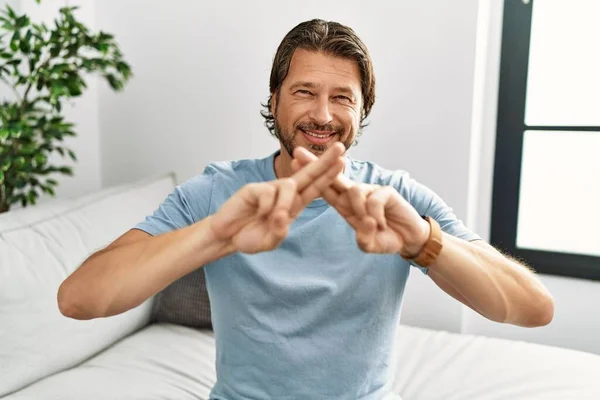 中世の白人男性は家で聴覚障害者の手話と自信を持ってコミュニケーションを笑っています — ストック写真