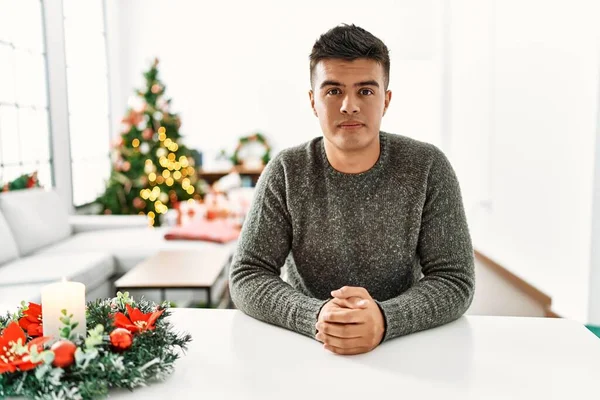 Junger Hispanischer Mann Der Entspannt Auf Dem Tisch Weihnachtsbaum Sitzt — Stockfoto