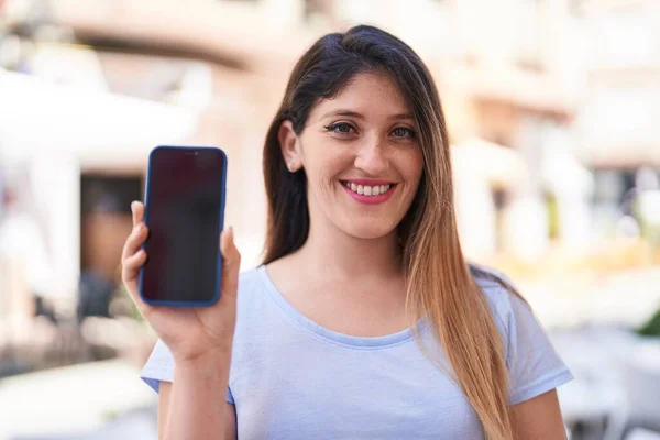 Junge Hispanische Frau Lächelt Selbstbewusst Und Zeigt Smartphone Bildschirm Auf — Stockfoto