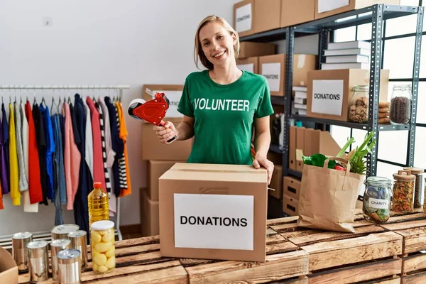 Gönüllü Üniformalı Beyaz Bir Kadın Yardım Merkezinde Çalışan Karton Kutuları — Stok fotoğraf
