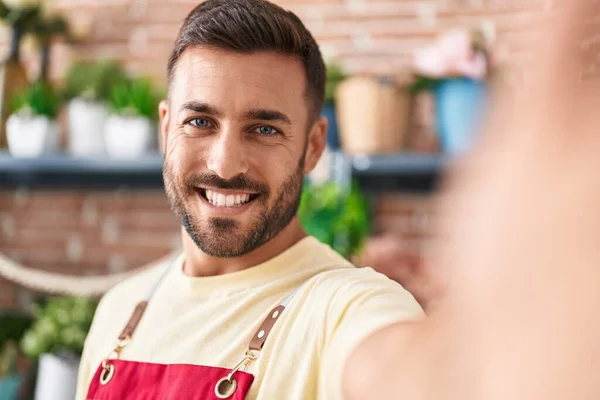 Young hispanic man florist smiling confident make selfie by camera at florist