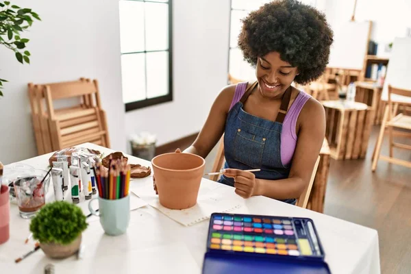在艺术工作室里 年轻的非洲裔美国女人笑着自信地画泥壶 — 图库照片