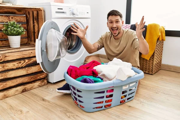 Jovem Homem Bonito Colocando Roupa Suja Máquina Lavar Roupa Celebrando — Fotografia de Stock