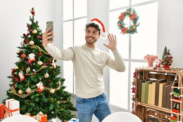 Young Hispanic Man Wearing Christmas Hat Making Selfie Smartphone Home — Foto de Stock