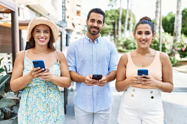 Tre Amici Ispanici Sorridenti Felici Usando Smartphone Città — Foto Stock