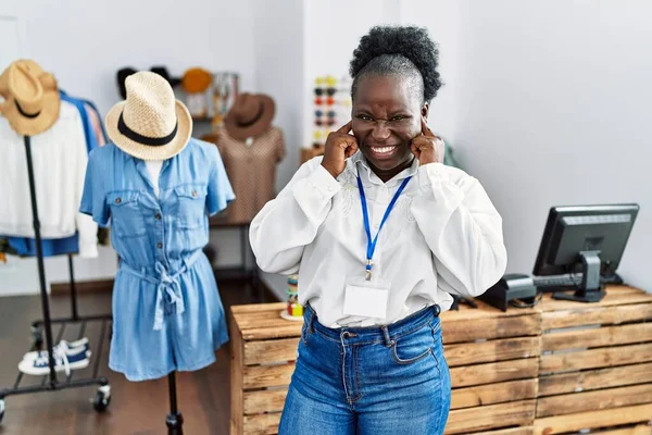 年轻的非洲女人是零售精品店的经理 她用手指捂住耳朵 对嘈杂的音乐感到恼怒 聋人概念 — 图库照片