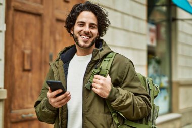 Şehirde akıllı telefon kullanan yakışıklı bir İspanyol.