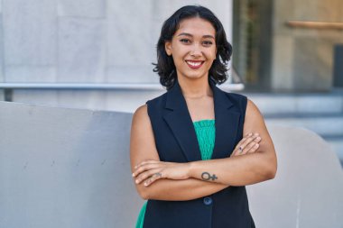 Sokakta kollarını kavuşturmuş genç, güzel İspanyol bir kadın.