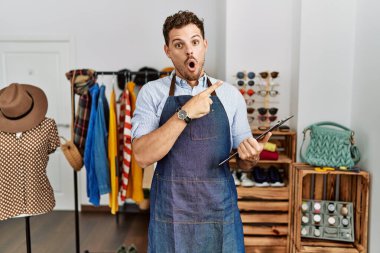 Perakende mağazası müdürü olarak çalışan yakışıklı genç adam parmağını yana doğru göstererek şaşırdı, ağzı açık hayret içinde kaldı.. 