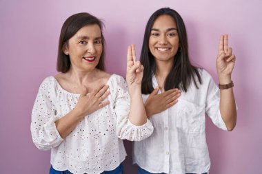 İspanyol anne ve kızı birlikte gülümsüyor. Elleri göğsünde, parmakları havada yemin ediyorlar. Sadakat yemini ediyorlar. 