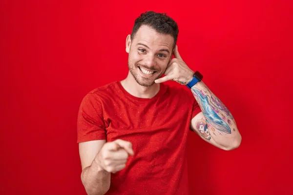 Joven Hombre Hispano Pie Sobre Fondo Rojo Sonriendo Haciendo Hablar —  Fotos de Stock