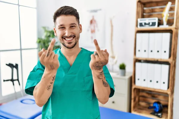Young Physiotherapist Man Working Pain Recovery Clinic Showing Middle Finger — Stockfoto