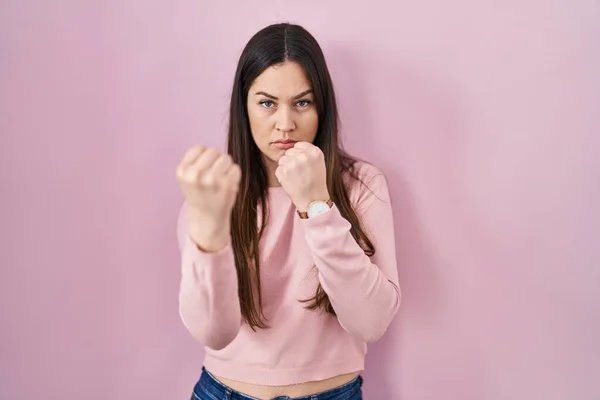 Mladá Brunetka Žena Stojící Nad Růžovým Pozadím Připravena Bojovat Gestem — Stock fotografie