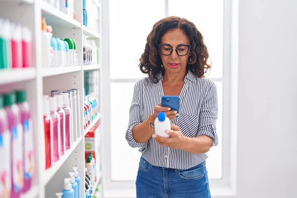 中年妇女客户在药店用智能手机给药瓶拍照 — 图库照片
