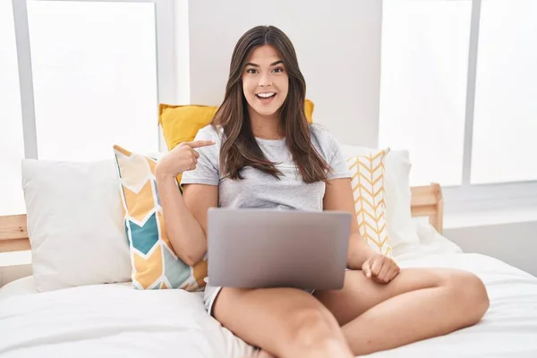 Mujer Hispana Usando Computadora Portátil Cama Apuntando Con Dedo Uno —  Fotos de Stock