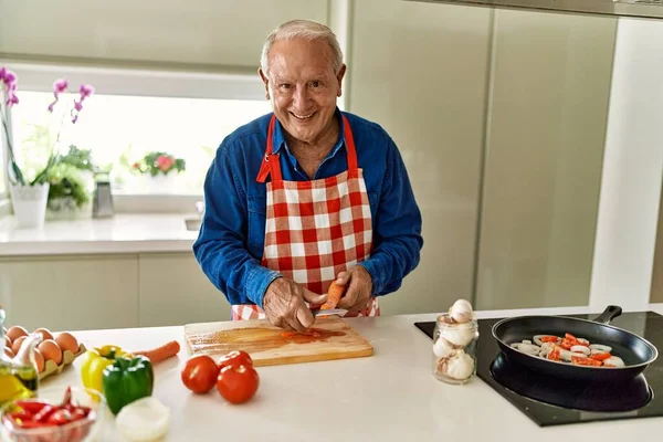 Senior Άνθρωπος Χαμογελά Αυτοπεποίθηση Κοπής Καρότο Στην Κουζίνα — Φωτογραφία Αρχείου