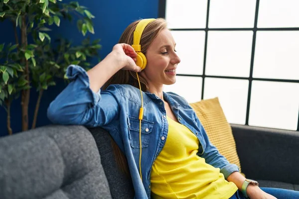 Young Blonde Woman Listening Music Sitting Sofa Home — Stok fotoğraf