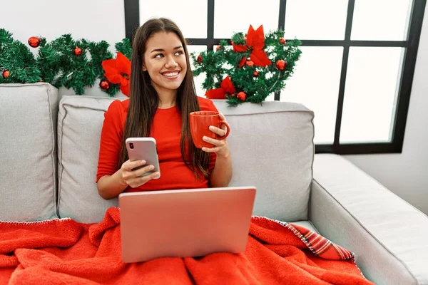 Wanita Latin Muda Menggunakan Smartphone Duduk Dekat Dekorasi Natal Rumah — Stok Foto