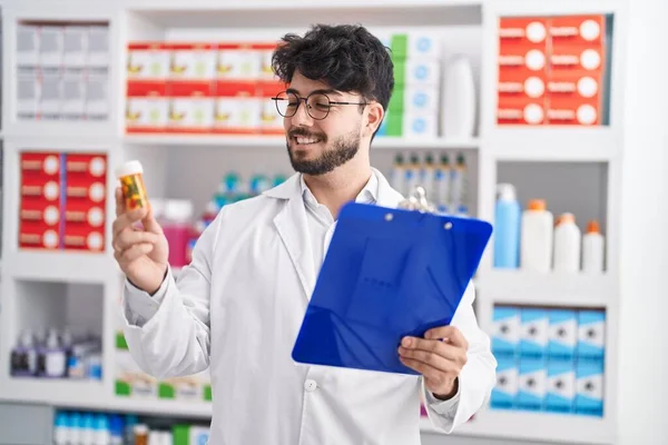 Giovane Uomo Ispanico Farmacista Possesso Pillole Bottiglia Lettura Prescrizione Farmacia — Foto Stock