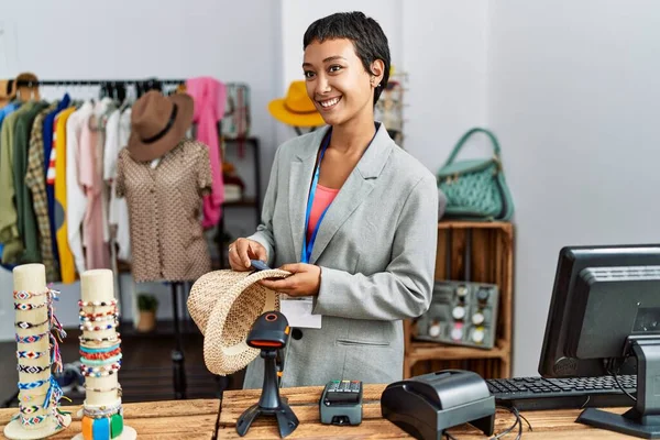 Young Hispanic Woman Shopkeeper Smiling Confident Holding Hat Security Alarm — Stock Fotó