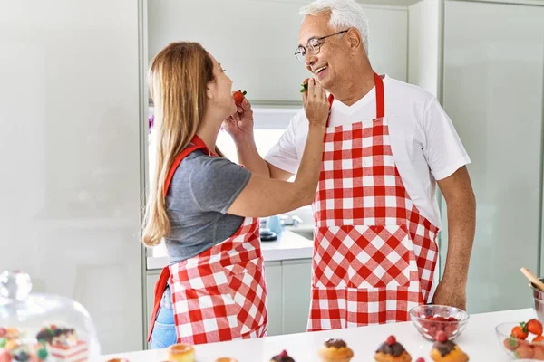 Casal Hispânico Meia Idade Sorrindo Feliz Dando Morango Outro Cozinha — Fotografia de Stock