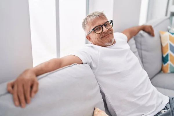 Středního Věku Šedovlasý Muž Usměvavý Sebevědomě Sedí Pohovce Doma — Stock fotografie