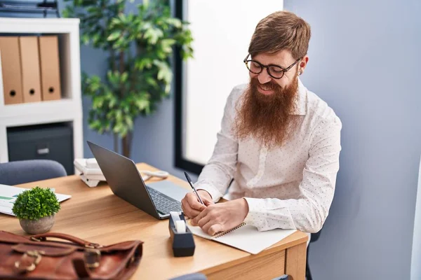 オフィスのノートパソコンでノートパソコンを使ってる若い赤毛のサラリーマン — ストック写真