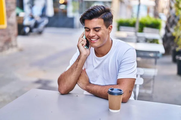 Junger Hispanischer Mann Spricht Auf Smartphone Und Trinkt Kaffee Auf — Stockfoto
