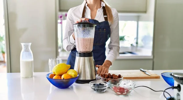 Young Blonde Woman Liquefying Smoothie Using Bender Kitchen — 스톡 사진