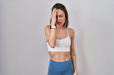 İzole edilmiş arka planda spor giyinen İspanyol kadın yarı yüz, göz ve ağız ile esnemekten yorulmuş. Yüzüm acıyor.. 