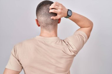 İzole edilmiş arka planda duran genç adam elleri başının üstünde şüpheyi düşünüyor. 