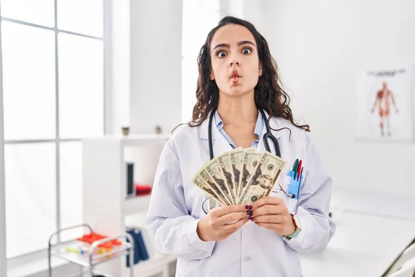 Joven Doctora Sosteniendo Dinero Haciendo Cara Pez Con Boca Ojos — Foto de Stock