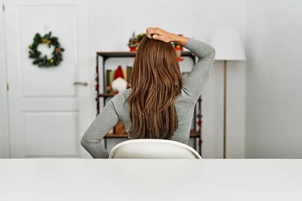 Young Latin Woman Sitting Table Christmas Decor Backwards Thinking Doubt — Stok fotoğraf