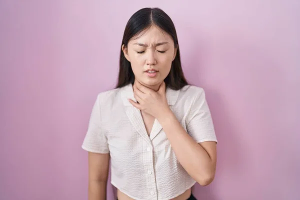 Mujer Joven China Pie Sobre Fondo Rosa Tocando Cuello Doloroso —  Fotos de Stock