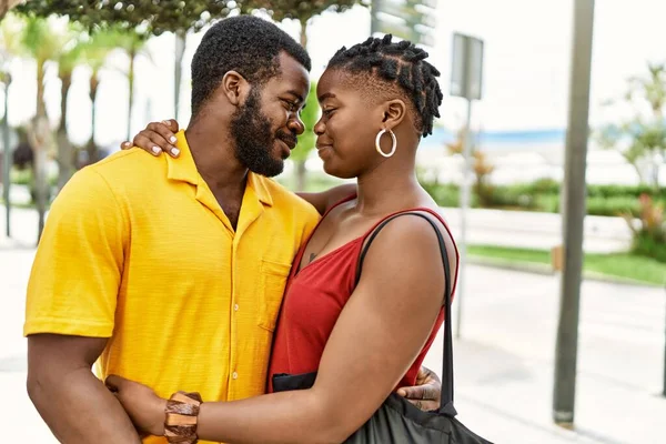 Genç Afro-Amerikan çifti mutlu bir şekilde gülümsüyor ve şehre sarılıyorlar..