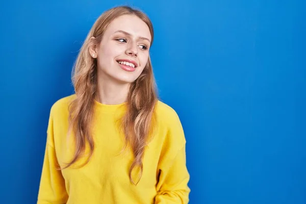 Young Caucasian Woman Standing Blue Background Looking Away Side Smile —  Fotos de Stock