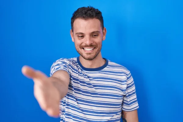 Jovem Hispânico Homem Sobre Fundo Azul Sorrindo Alegre Oferecendo Palma — Fotografia de Stock