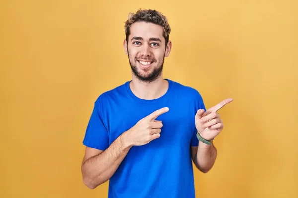 Hispanic Man Beard Standing Yellow Background Smiling Looking Camera Pointing — Stockfoto