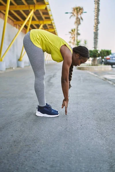 ストリートでスポーツウェアストレッチ足を身に着けているアフリカ系アメリカ人女性 — ストック写真