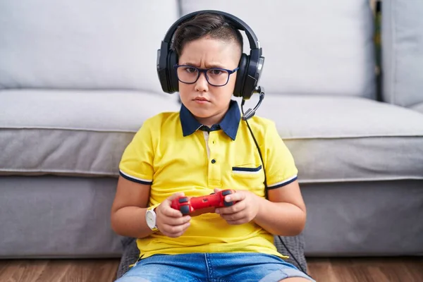 Joven Niño Hispano Jugando Videojuego Sosteniendo Controlador Usando Auriculares Escépticos —  Fotos de Stock