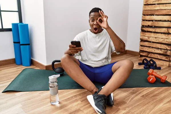 Young African Man Sitting Training Mat Gym Using Smartphone Doing — Stok fotoğraf