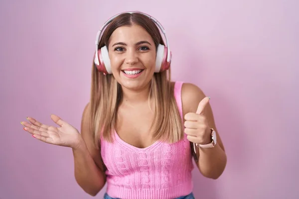 Young Blonde Woman Listening Music Using Headphones Showing Palm Hand — Foto de Stock
