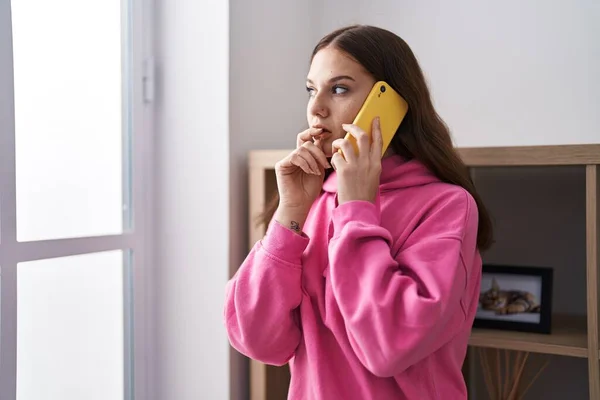 Young Woman Talking Smartphone Worried Expression Home — Stockfoto