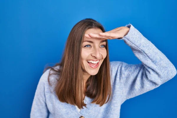 Young Woman Standing Blue Background Very Happy Smiling Looking Far — Stockfoto
