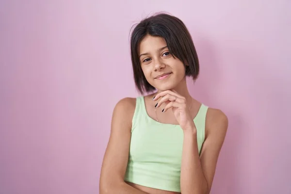 Junges Mädchen Das Über Rosa Hintergrund Steht Und Selbstbewusst Die — Stockfoto