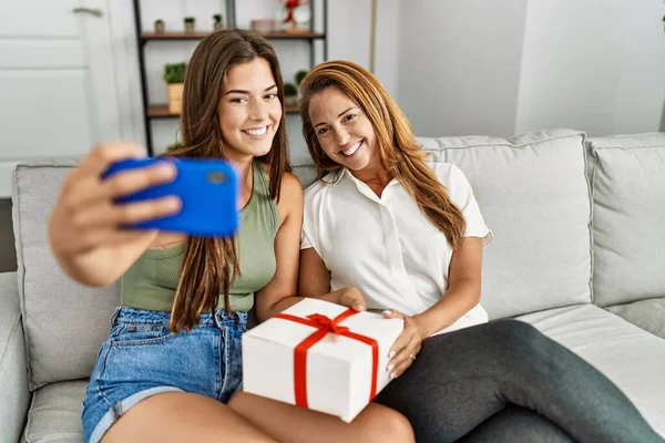 Mother Daughter Smiling Confident Holding Gift Making Selfie Smartphone Home — Stock fotografie